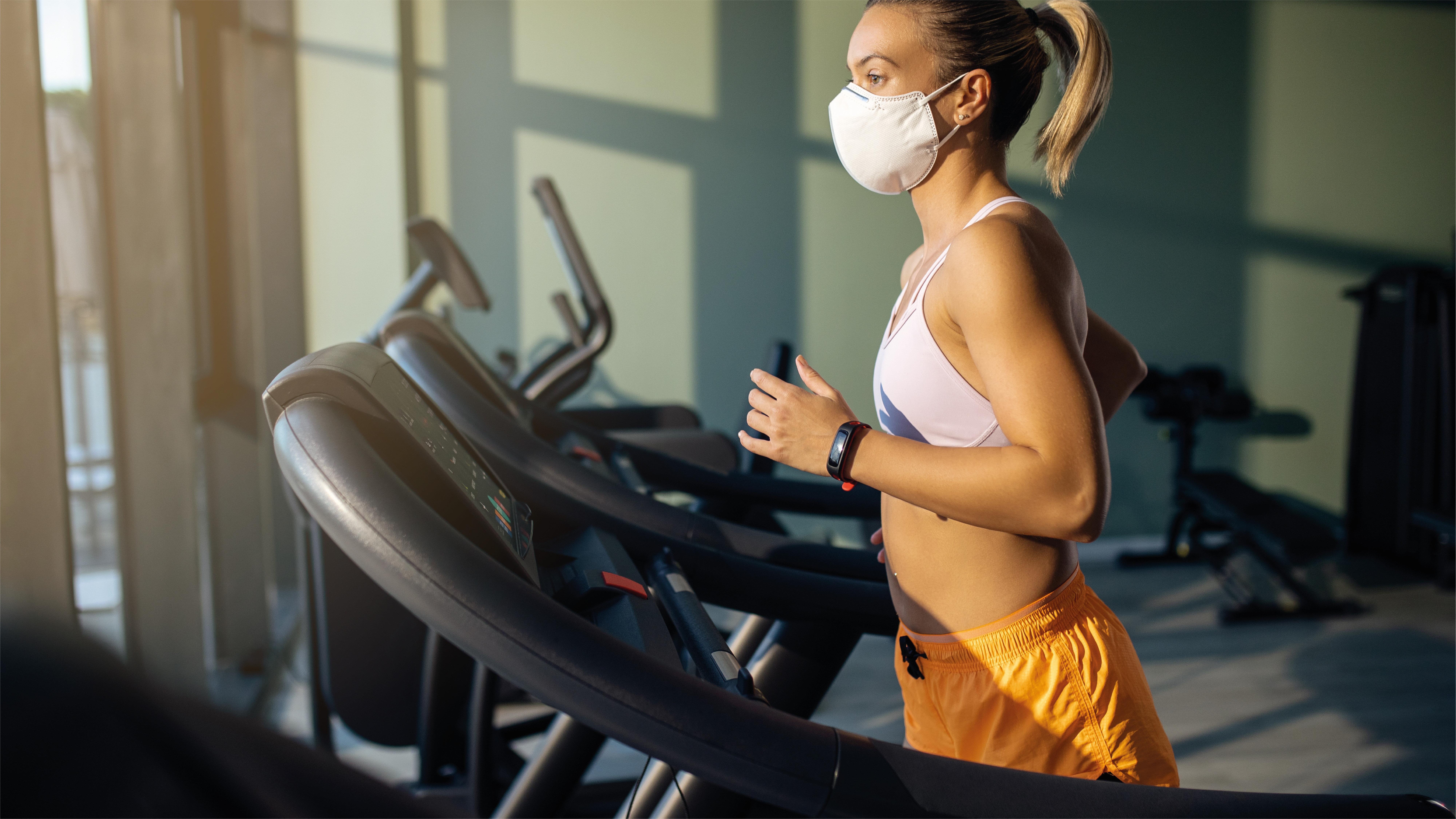 Voco Dubai By Ihg Hotel Bagian luar foto A woman wearing a face mask while exercising on a treadmill
