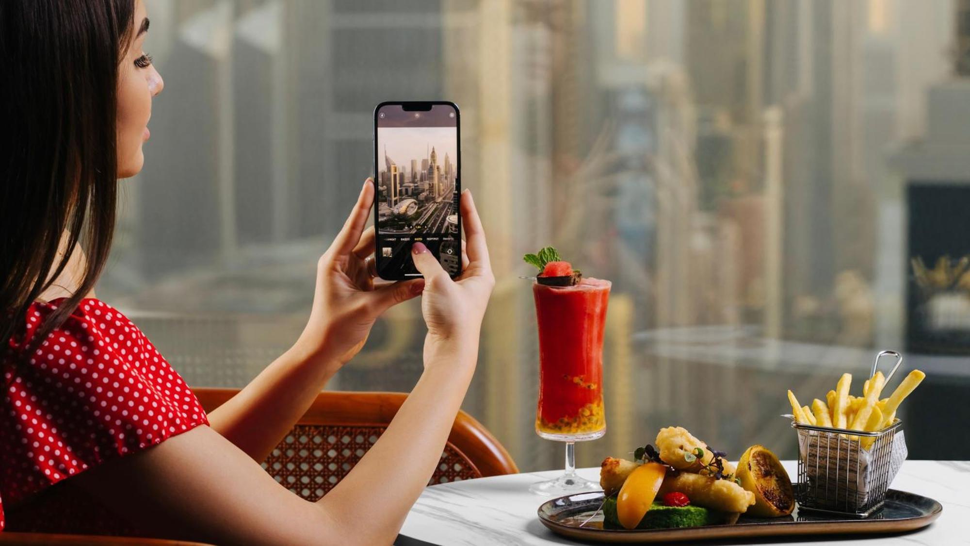 Voco Dubai By Ihg Hotel Bagian luar foto A woman taking a photo with a smartphone